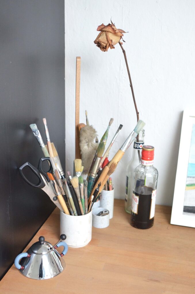 A collection of painting brushes neatly arranged in a cup.